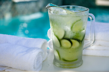 Glass pitcher with cold water, cucumbers and mint