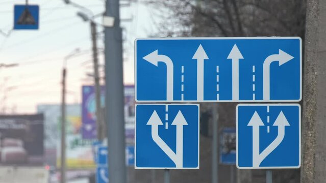 Traffic sign pointing multiple road lanes direction on city street. Signboard arrows for urban transport safety guidance