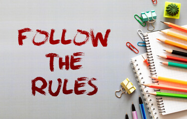 Follow The Rules text written on a notebook with pencils