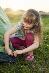 Just call me the camp master. Cropped shot of a little girl putting up a tent by herself.