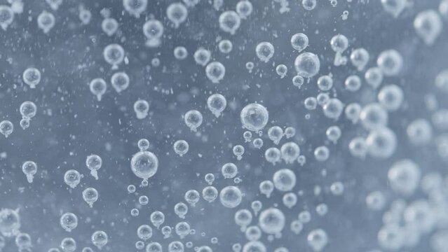 Abstract Closeup of Carbon Dioxide Bubbles Floating and Popping Inside a Transparent Glass that contains an Effervescent Tablet Pill - Fizzy Soda Drink Shot in 4K Macro and Slow Motion
