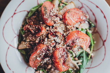 close up of a gourmet salad with tomatoes, cereal mix and arugula
