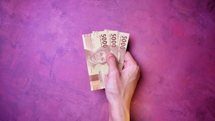 Indonesian Rupiah the official currency of Indonesia. Man's hand is making a payment. Business...