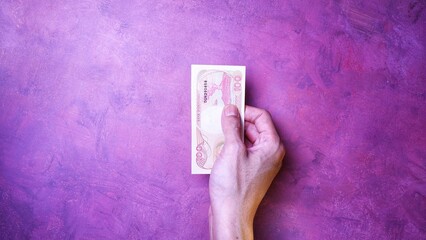 Indonesian Rupiah the official currency of Indonesia. Man's hand is making a payment. Business...