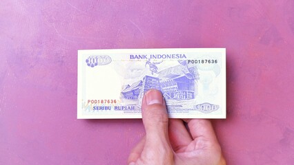 Indonesian Rupiah the official currency of Indonesia. Man's hand is making a payment. Business...