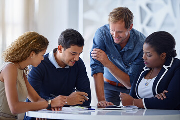 Obraz premium Bringing their ideas into reality. Shot of a group of colleagues working together in an office.