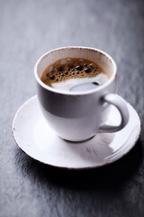 Cup of coffee on dark stone background. Close up.