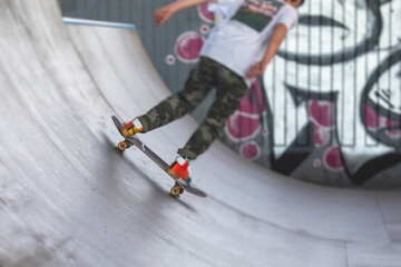 Skate park view with kids on a kick scooter doing tricks and stunts, boys in a skate park riding bmx bike and skate, playing and enjoying summer on new ramp, teenagers skateboarders and bmx riders