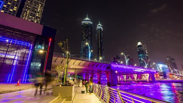 night illumination dubai water canal side walk fountain bridge panorama 4k time lapse uae