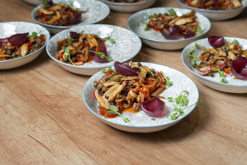 Beef tongue with champignon mushrooms, salad with onions and capers. Dishes in a restaurant on the table.