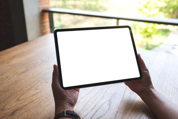 Mockup image of a woman holding digital tablet with blank white desktop screen