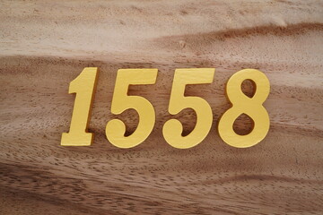 Golden Arabic numerals on a real brown and white wooden floor number 1558