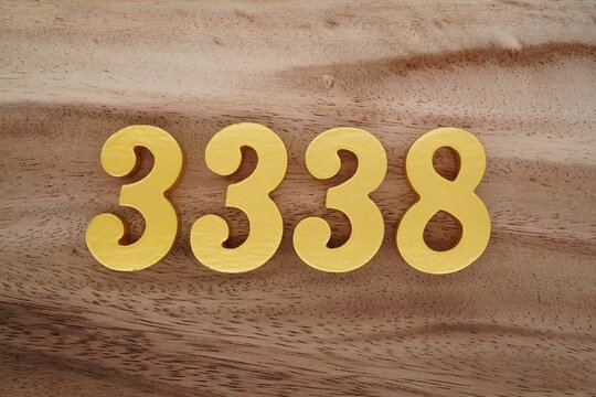 Golden Arabic numerals on a real brown and white wooden floor number 3338