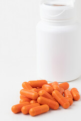 Bottle of multivitamin orange capsules.