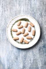 Ashwagandha (Withania somnifera) tablets. Wooden background. Soft focus. Top view. Copy space.