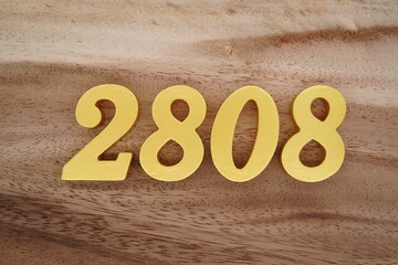 Golden Arabic numerals on a real brown and white wooden floor number 2808