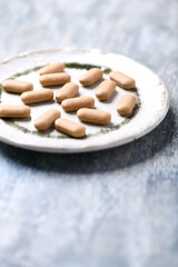 Ashwagandha (Withania somnifera) tablets. Wooden background. Soft focus. Close up. Copy space.