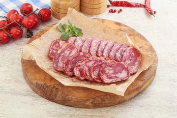 Sliced salami sausages over board