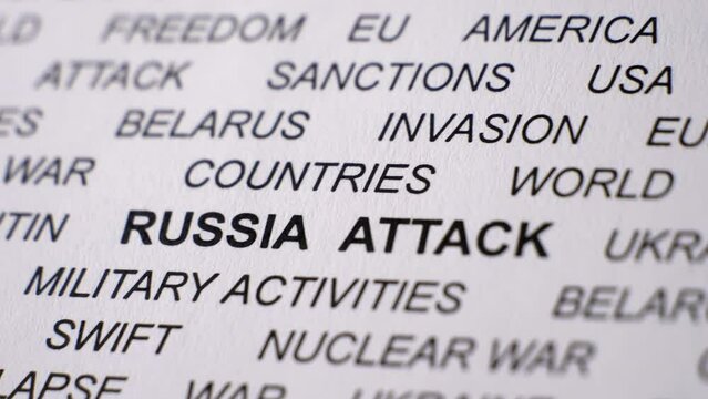 Closeup shot of RUSSIA ATTACK written on white paper. Russian invasion of Ukraine concept. Crisis. Military activities. Sanctions. Camera slowly turning right.
