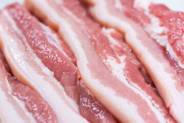 Closeup top view pieces fresh raw meat of pork belly with white fat and red pink meat