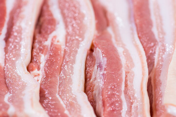 Closeup top view pieces fresh raw meat of pork belly with white fat and red pink meat