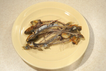 Gnawed fish skeletons and backbones lie on a plate.