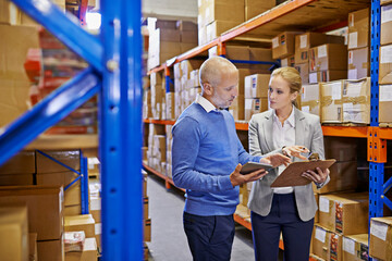 WE always double check our shipments. Shot of a man and woman inspecting inventory in a large...