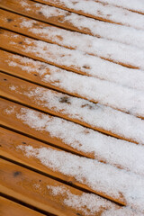 Abstract texture background of melting snow on a hardwood cedar deck in springtime