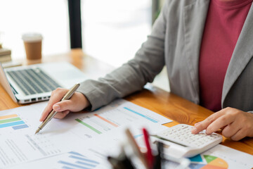 Business analyst concept the data analyst calculating the diagrams about the sale on the paperwork