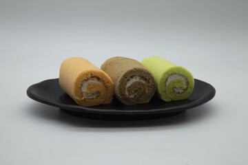 Jam rolls or soft bakery roll cakes in a black tray Popular with coffee white background,Include Clipping Path.