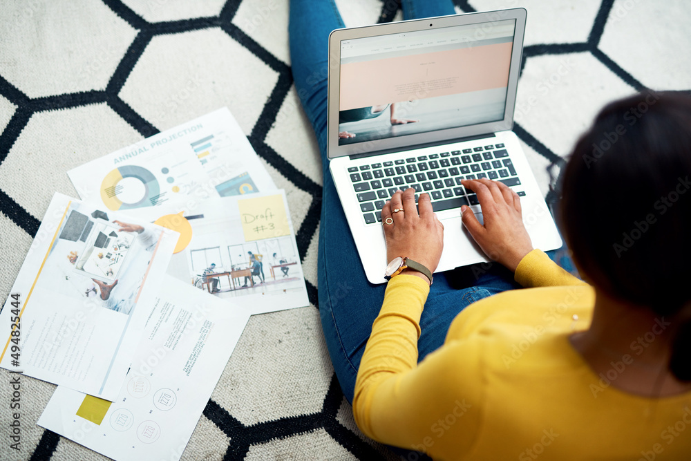 Poster updating my data. cropped shot of an unrecognizable woman sitting on the floor and using her laptop 