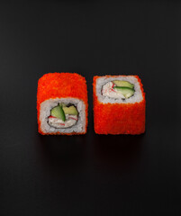 maki sushi with masago caviar on black background closeup © uventa