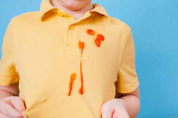 Close up stain tomato sauce spilled on children's outfit. The concept of cleaning stains on clothes