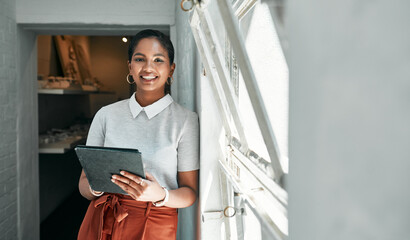 Go-getters know how to get it all done. Portrait of a young businesswoman using a digital tablet in...