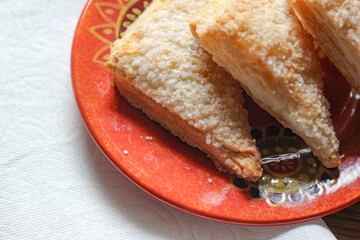 Turnovers Apple, Apple Pie, placed on an orange plate. with paper napkins Turnovers Apple is a popular dish in America