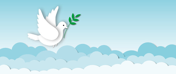 Paper white dove or pigeon carrying olive branch flying in cloudy sky background, Concept for World Peace Day, international day of peace, space for the text, paper cut design style.