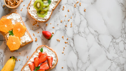 Healthy breakfast toasts with copy space on white marble background.