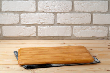 Cutting board with cotton napkin on wooden table
