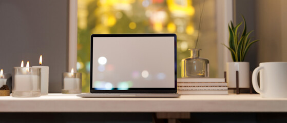 Notebook laptop computer mockup on white tabletop against the window with bokeh lights