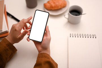 Overhead shot, Female hands using modern smartphone while having a breakfast