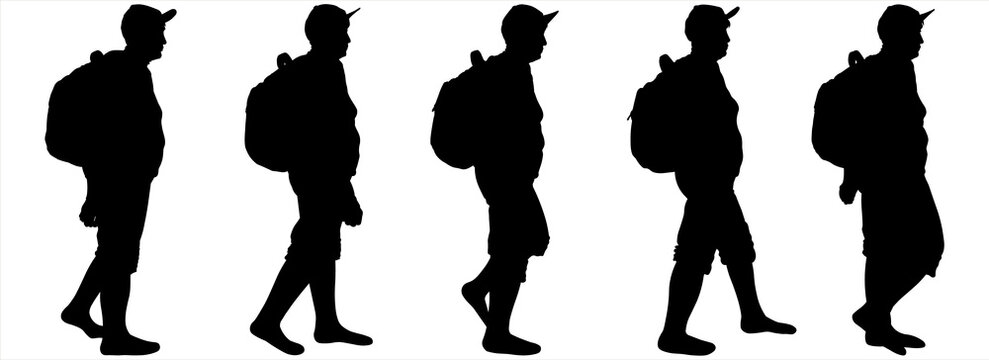 Tourists with backpacks walk one after another. A group of walking tourists. A woman in a sports cap, a backpack behind her back, shorts. An older woman is hiking. Hiking. Side view, profile.	