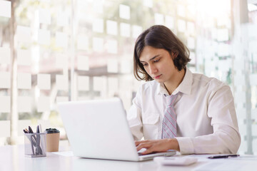 Business concept, Businessman analyzing statistical to typing financial report on laptop in office