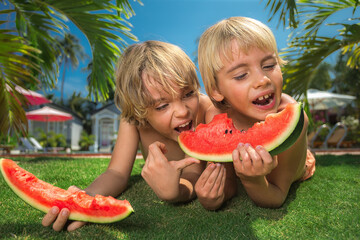 Happy kids eating watermelons.