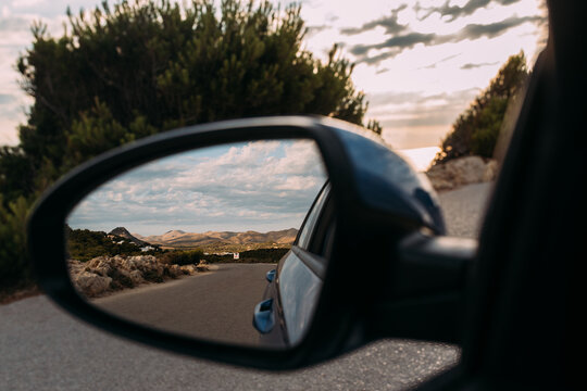 Rückblick nach Hinten in einem Spiegel im Mietwagen bei einer Rundreise auf Mallorca