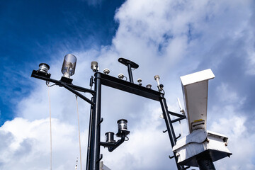 Ship's mast with navigation equipment, view from below against the sky. Radar, signal lights, navigation antennas and equipment.