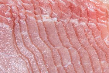 Closeup top view pieces raw meat of fresh pork slices are sliced into thin strips stacked on top of each other