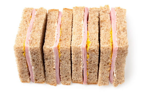 Row of ham and mustard wholewheat triangle sandwiches