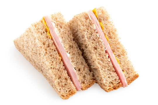 Two ham and mustard wholewheat triangle sandwiches.