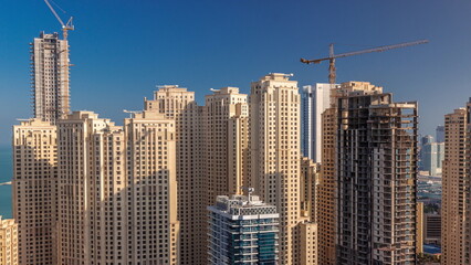 Fototapeta na wymiar Jumeirah Beach Residence and original architecture yellow towers in Dubai aerial timelapse.