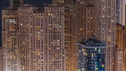 Jumeirah Beach Residence and original architecture yellow towers in Dubai aerial night timelapse.